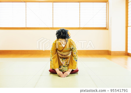 日式房間裡穿著和服打招呼的女人 95541791
