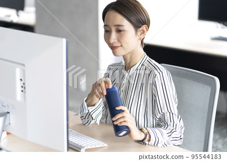 Woman using my bottle in the office Woman using my bottle in the office 95544183