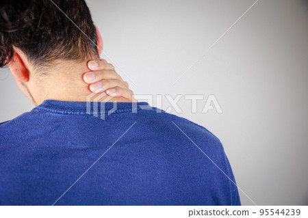 Rear view of a man with his hand on his shoulder Rear view of a man with his hand on his shoulder 95544239