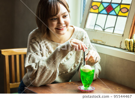 在咖啡館喝甜瓜蘇打水的可愛女人 在咖啡館喝甜瓜蘇打水的可愛女人 95544467