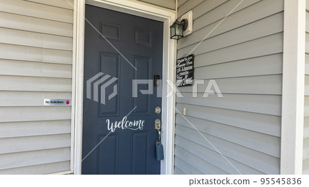 Panorama Blue front door of a house with white welcome calligraphy at the front 95545836