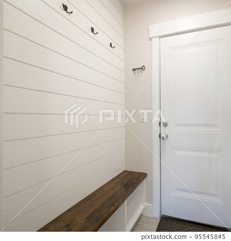 Square Mudroom interior with white door to the garage and wood panel interior 95545845