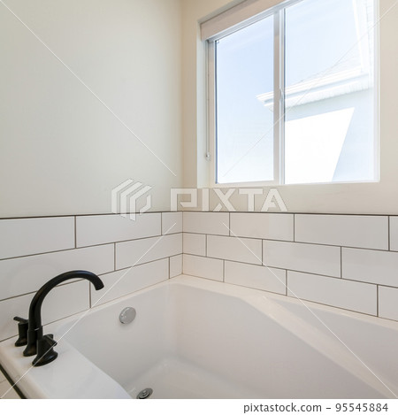 Square Alcove bathtub with white subway tiles surround with black grout 95545884