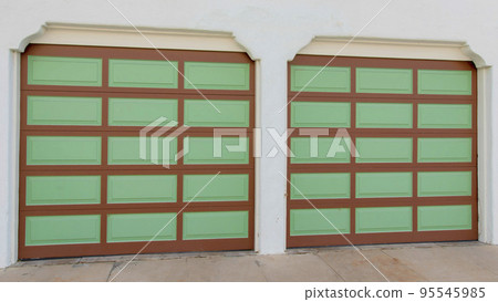 Panorama Two garage doors with brown grid lines and green panels at La Jolla, California 95545985