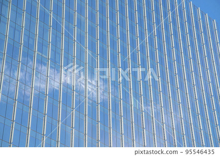 Modern building with a modern glass exterior that reflects the clear blue sky 95546435