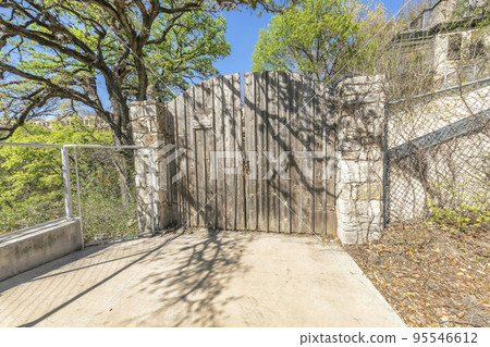 Old wooden gate with stone posts at the entrance of a property in Austin Texas 95546612