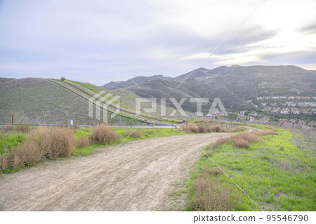 Flattened hiking trail on a mountain with grasses on the side in San Clemente, California Flattened hiking trail on a mountain with grasses on the side in San Clemente, California 95546790