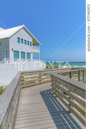 Destin, Florida- Boardwalk with a view of beach house and ocean 95546803