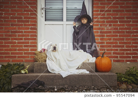 Adorable child with dog on porch dressed in halloween costumes Adorable child with dog on porch dressed in halloween costumes 95547094