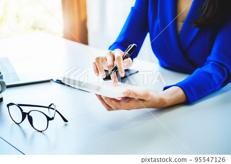 accountant, Auditor, Self-Employed, Finance and Investment, tax calculation and budget, Asian female entrepreneur using a calculator to calculate. Company business results document 95547126