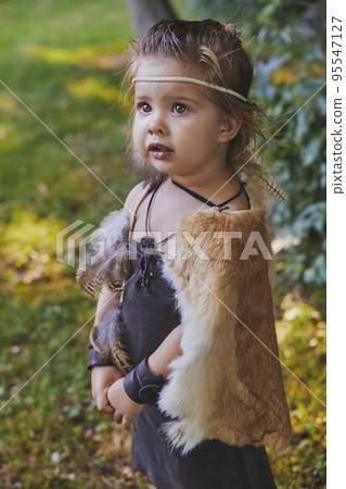 Cute baby dressed in the clothes of primitive people 95547127