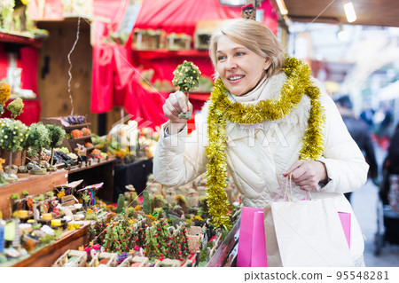 Woman is preparing for Christmas and choosing decorations for her house Woman is preparing for Christmas and choosing decorations for her house 95548281