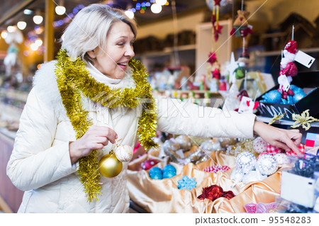 Smiling woman choosing Christmas toys at Christmas market 95548283