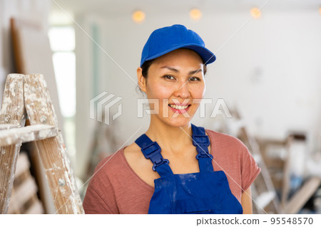 Portrait of positive woman builder during repair works Portrait of positive woman builder during repair works 95548570