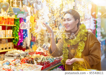 Woman purchasing christmas decorations Woman purchasing christmas decorations 95548611