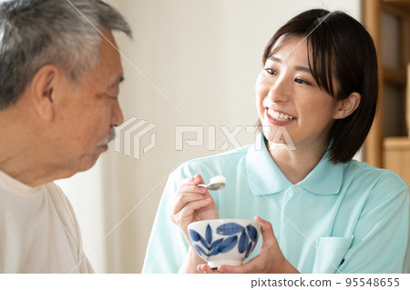 Caregiver feeding seniors Caregiver feeding seniors 95548655