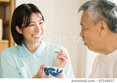 Caregiver feeding seniors 95548657