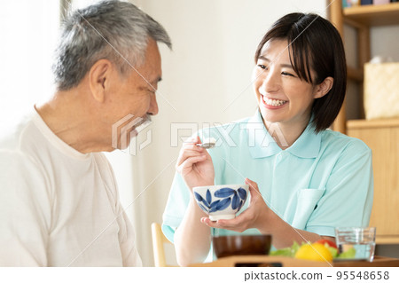 Caregiver feeding seniors 95548658