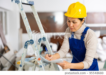 Woman signs an act of acceptance of completed work Woman signs an act of acceptance of completed work 95548680