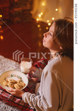 Cute boy ready for Santa Claus waiting with cookies and milk. Belief in fairy tale 95549198