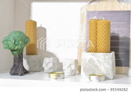 modern trendy loft house decor, beeswax candles, concrete boxes and vases. tea candles and cement accessories. minimal scandinavian style decoration. 95549262