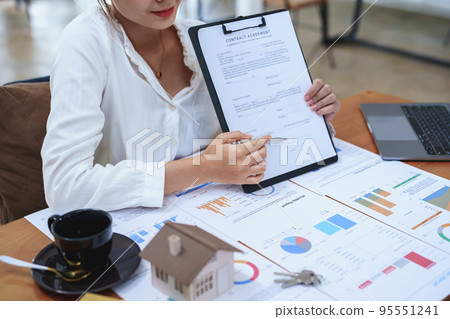 Portrait of a beautiful bank young woman sign credit department of signing approval for a home loan. 95551241