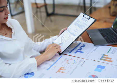 Portrait of a female business owner reading important documents before signing to verify approval of investment budget for their company. 95551242