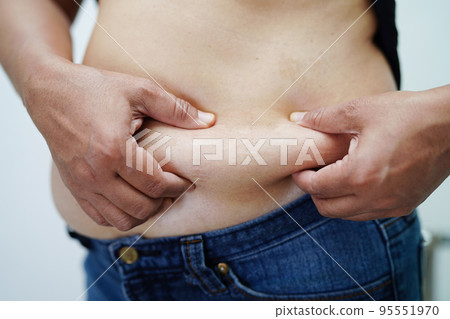 Overweight asian woman use hand to squeeze fat belly big size overweight and obesity. Overweight asian woman use hand to squeeze fat belly big size overweight and obesity. 95551970