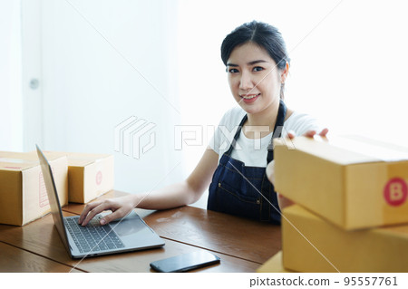 Starting small business entrepreneur of independent Asian woman smiling using laptop computer with cheerful success of online marketing package box items and SME delivery concept. Starting small business entrepreneur of independent Asian woman smiling using laptop computer with cheerful success of online marketing package box items and SME delivery concept. 95557761
