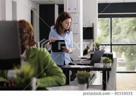 Employee analyzing report, comparing data on clipboard and laptop, office manager planning management strategy. Start up company worker holding document, working in coworking space 95559555