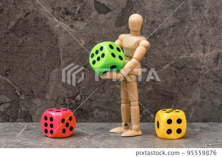 Wooden man with a three colored dices Wooden man with a three colored dices 95559876
