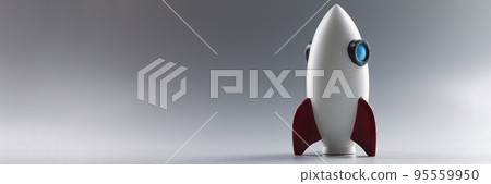 Rocket toy model stand on grey surface, rocketship as symbol for business project 95559950