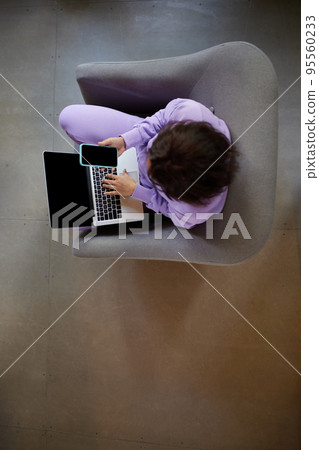 Top view image of woman sitting on chair at home and typing on laptop, making online order, shopping 95560233
