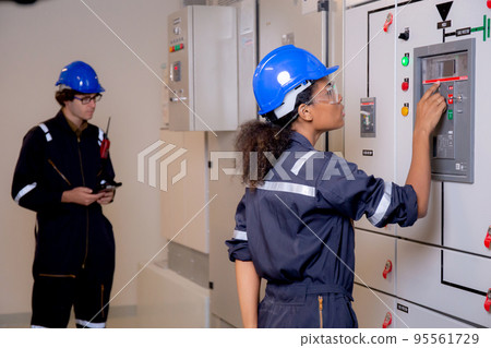 Young asian woman and man engineer examining maintenance cabinet system electric in control room. Young asian woman and man engineer examining maintenance cabinet system electric in control room. 95561729