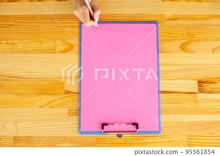 Office Hand Holding a Folder with a Pink Color Paper and Pen on the Background of the Wooden Table. Copyspace. Place for Text Office Hand Holding a Folder with a Pink Color Paper and Pen on the Background of the Wooden Table. Copyspace. Place for Text 95561854