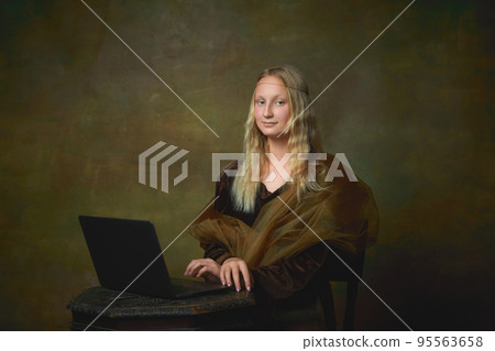 Young charming girl in image of Mona Lisa, La Gioconda using laptop isolated on dark green background. Creative art, beauty, style, imitation, eras comparison Young charming girl in image of Mona Lisa, La Gioconda using laptop isolated on dark green background. Creative art, beauty, style, imitation, eras comparison 95563658