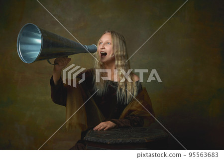 Beautiful young girl with long blonde hair wearing medieval dress shouting at megaphone over dark vintage background. Retro style, art, fashion, comparison of eras concept. Beautiful young girl with long blonde hair wearing medieval dress shouting at megaphone over dark vintage background. Retro style, art, fashion, comparison of eras concept. 95563683