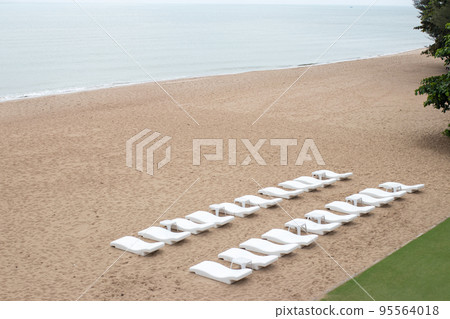 Lounge Chairs on sandy beach. 95564018