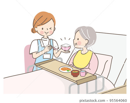 A caregiver helping a senior woman eat 95564060