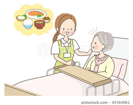 A caregiver helping a senior woman eat 95564061