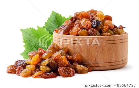 Raisins in a wooden plate with leaves close-up on a white background. Isolated Raisins in a wooden plate with leaves close-up on a white background. Isolated 95564755