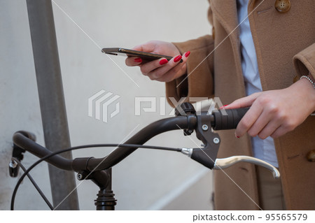 Woman in a beige coat searching for a route via gps 95565579