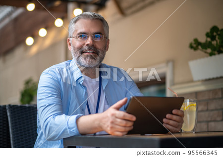 Gray-haired mid aged man with a laptop 95566345
