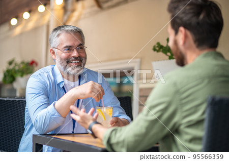 Two men sitting in the cafe and having an interesting conversation 95566359