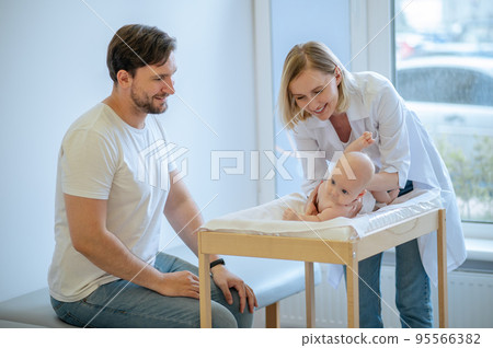 Pediatric doctor testing the newborn baby reflexes Pediatric doctor testing the newborn baby reflexes 95566382