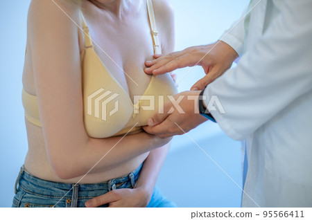 Mammologist palpating the female breast during the primary examination 95566411