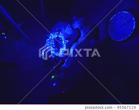The family fast and fanny decorates the Christmas tree. Top view. Time on the clock is 23.45 on wall. Happy dad, mom, daughter are run around tree. 95567119