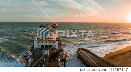 Aerial view of Brighton Palace Pier, with the seafront behind. Aerial shot of the stunning city of Brighton and Hove with seagulls flying around at sunset. Aerial view of Brighton Palace Pier, with the seafront behind. Aerial shot of the stunning city of Brighton and Hove with seagulls flying around at sunset. 95567147
