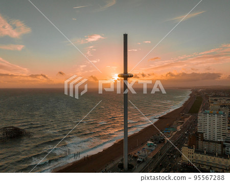 Magical sunset aerial view of British Airways i360 viewing tower pod with tourists in Brighton, UK with sea and Brighton Palace Pier in the background. Magical sunset aerial view of British Airways i360 viewing tower pod with tourists in Brighton, UK with sea and Brighton Palace Pier in the background. 95567288