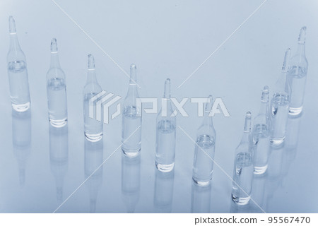Glass medical ampoule vial for injection. Medicine is dry white drug penicillin powder or liquid with of aqueous solution in ampulla. Close up. Glass medical ampoule vial for injection. Medicine is dry white drug penicillin powder or liquid with of aqueous solution in ampulla. Close up. 95567470